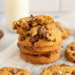 a stack of gooey chocolate chip cookies with sea salt
