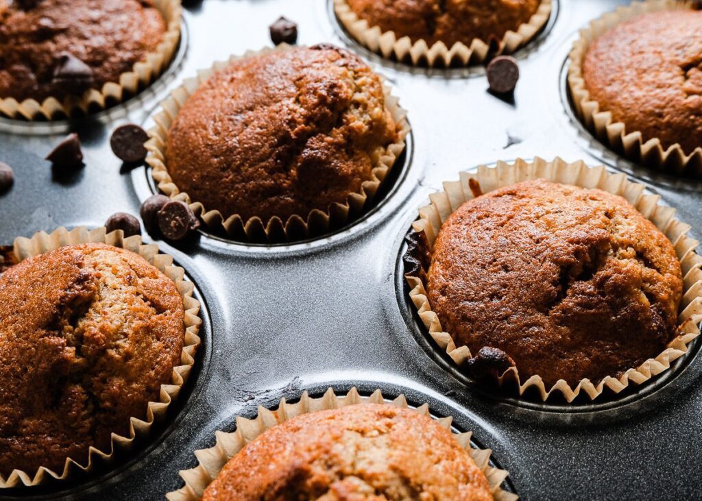 Close up shot of cooked banana muffins with golden top in muffin tray