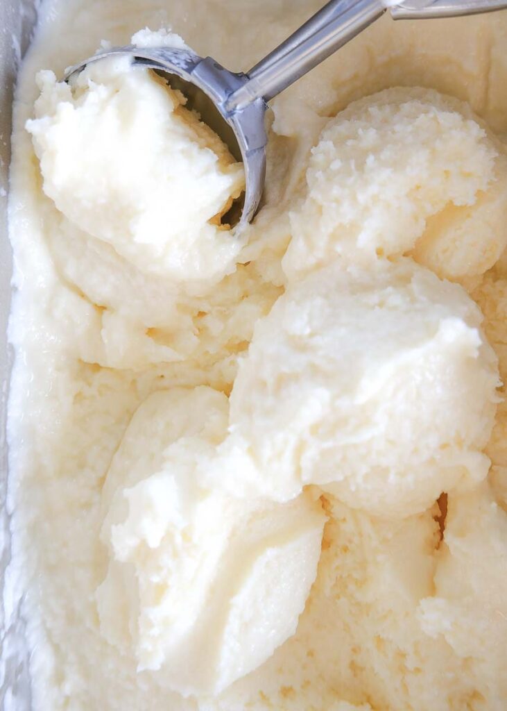 Close up of scooped vanilla ice cream with metal cookie scoop