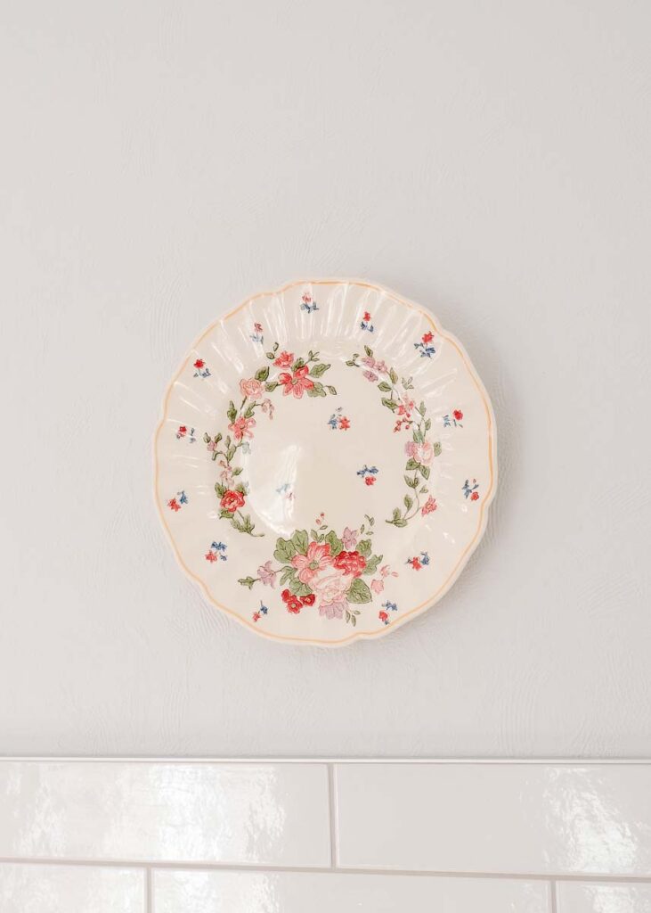 Vintage floral plate hanging on wall in kitchen