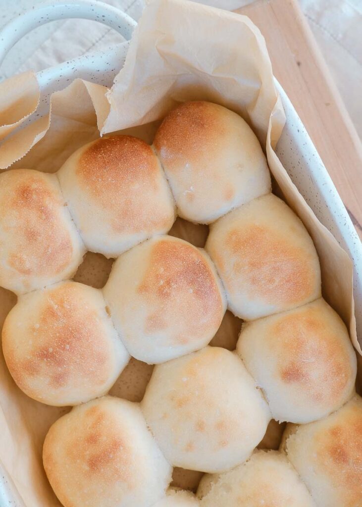 dinner rolls in a large baking dish fresh out of the oven. They are golden brown 
