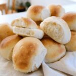 dinner rolls in a pile on the kitchen bench