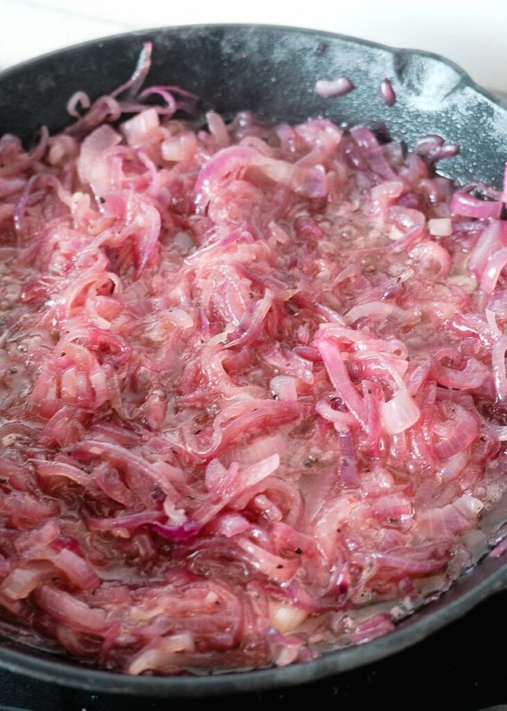Red onions simmering in olive oil on skillet fry