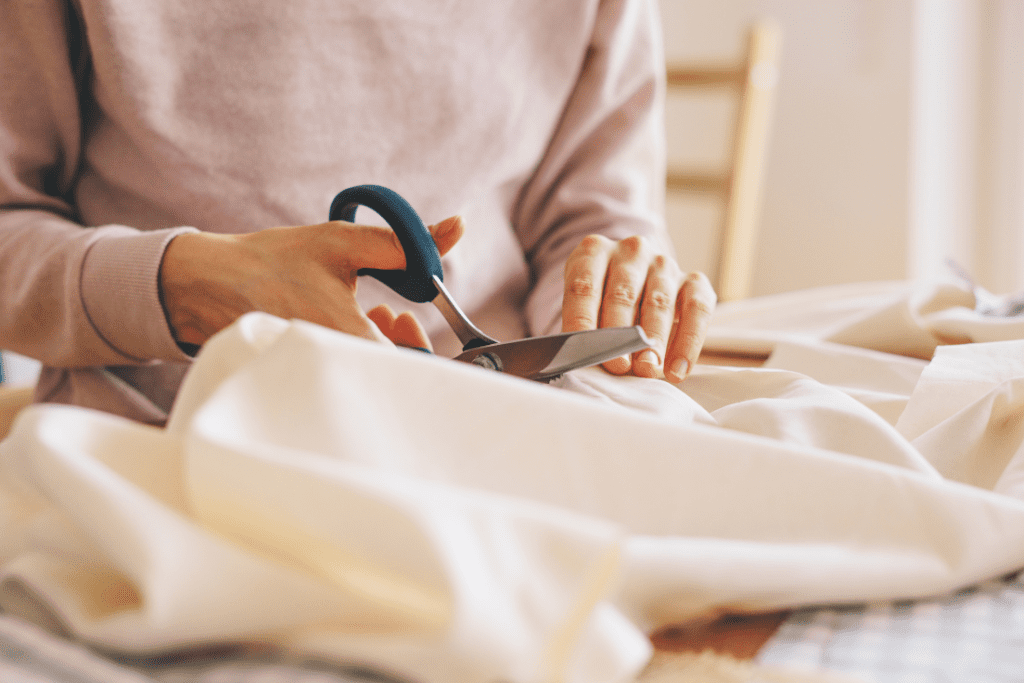 Women cutting fabric with fabric shears