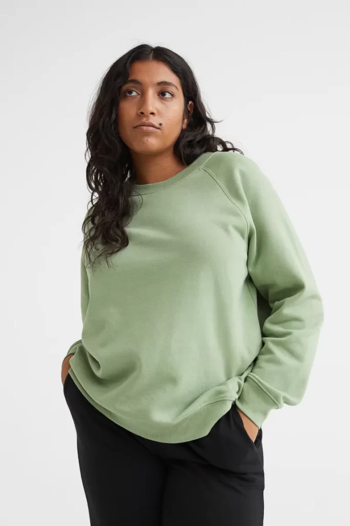 Woman wearing a green jumper with raglan sleeves
