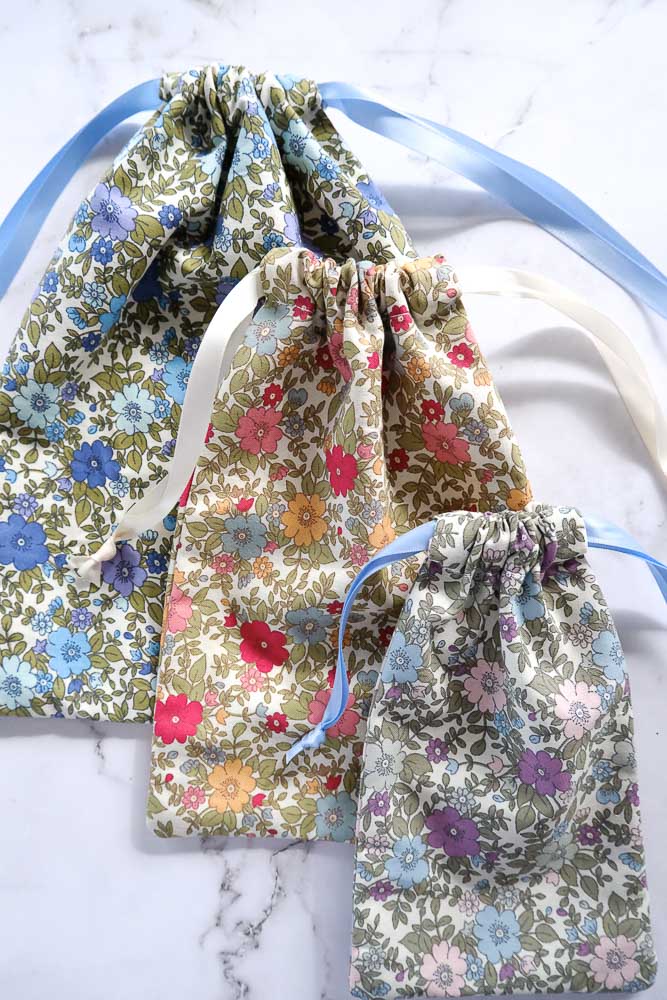 Set of three different sized drawstring bags in floral cotton prints