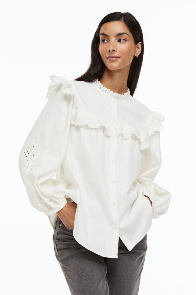 Girl wearing a white puff sleeve top that has cuffs around the sleeves