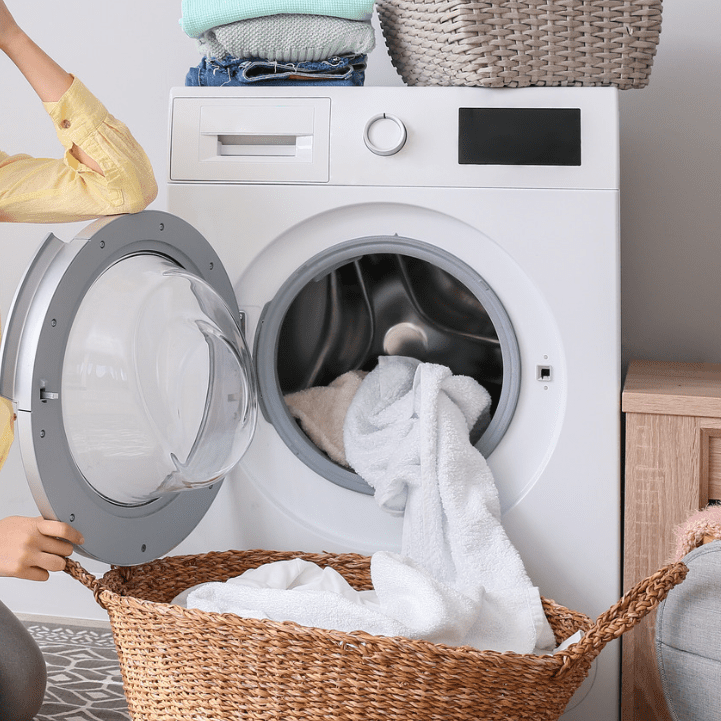 tumble dryer in laundry room with dry linen inside