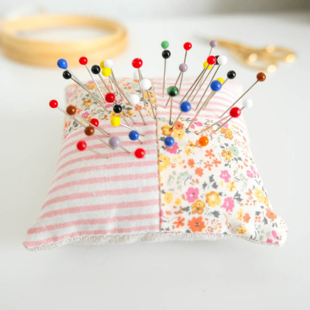 Pretty patchwork floral, stripe and linen pin cushion with pins inserted