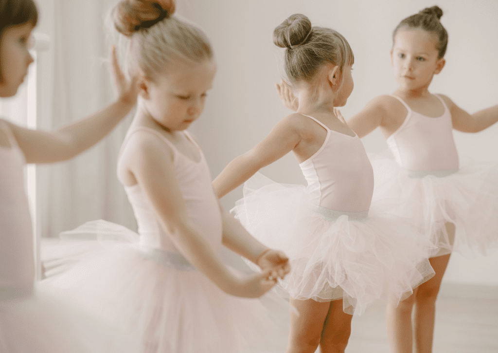 Little girls wearing tulle tutus while dancing