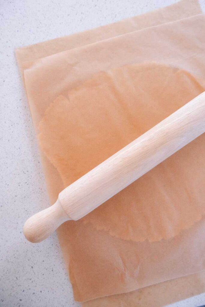 Rolling out cookie dough in between parchment paper