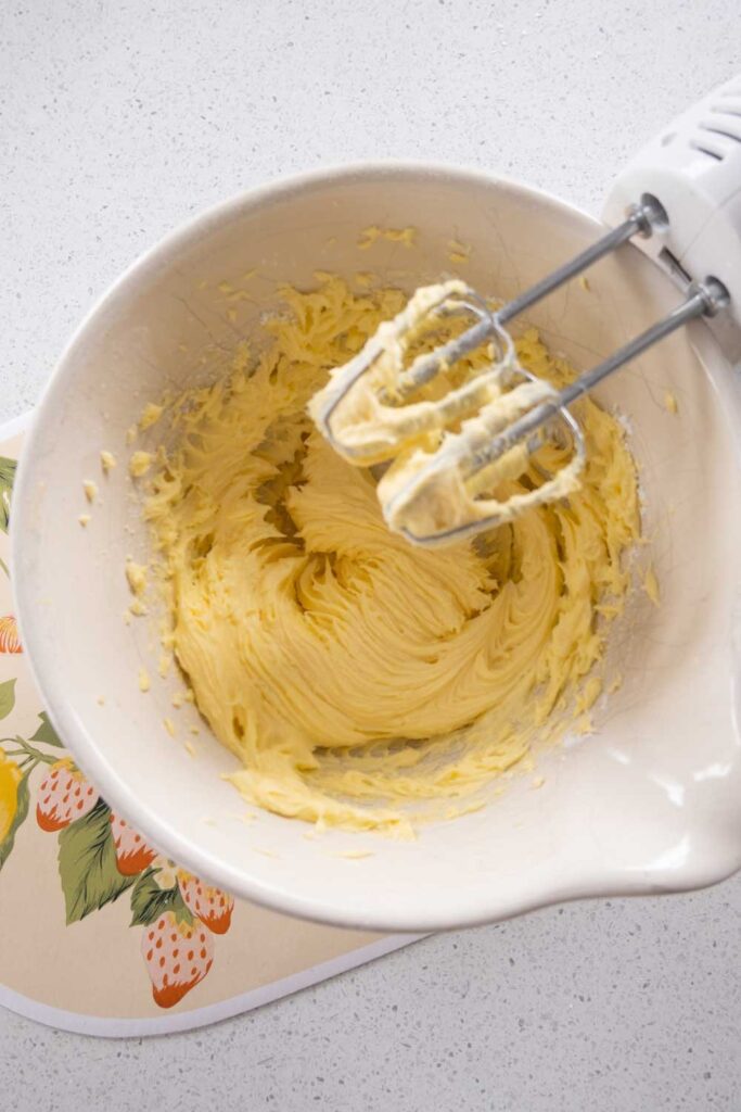 Creaming butter and icing sugar in a bowl