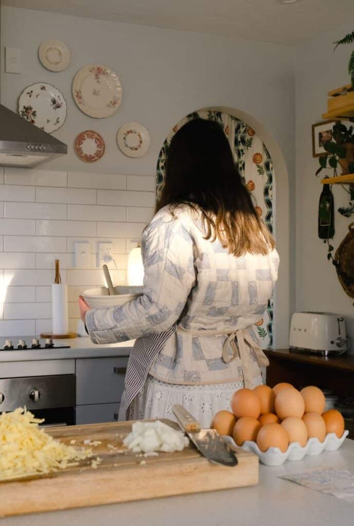 a young homemaking woman standing in her kitchen