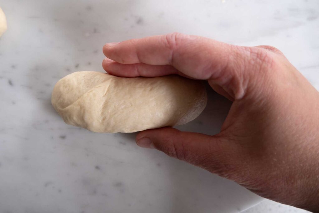 Adding tension to the dough to create long soft rolls