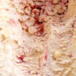 Close up shot of Raspberry White Chocolate Ice Cream with ripples of cream, jam and chocolate