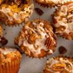 Close up of a pumpkin muffin with pecan streusel and maple drizzled on top