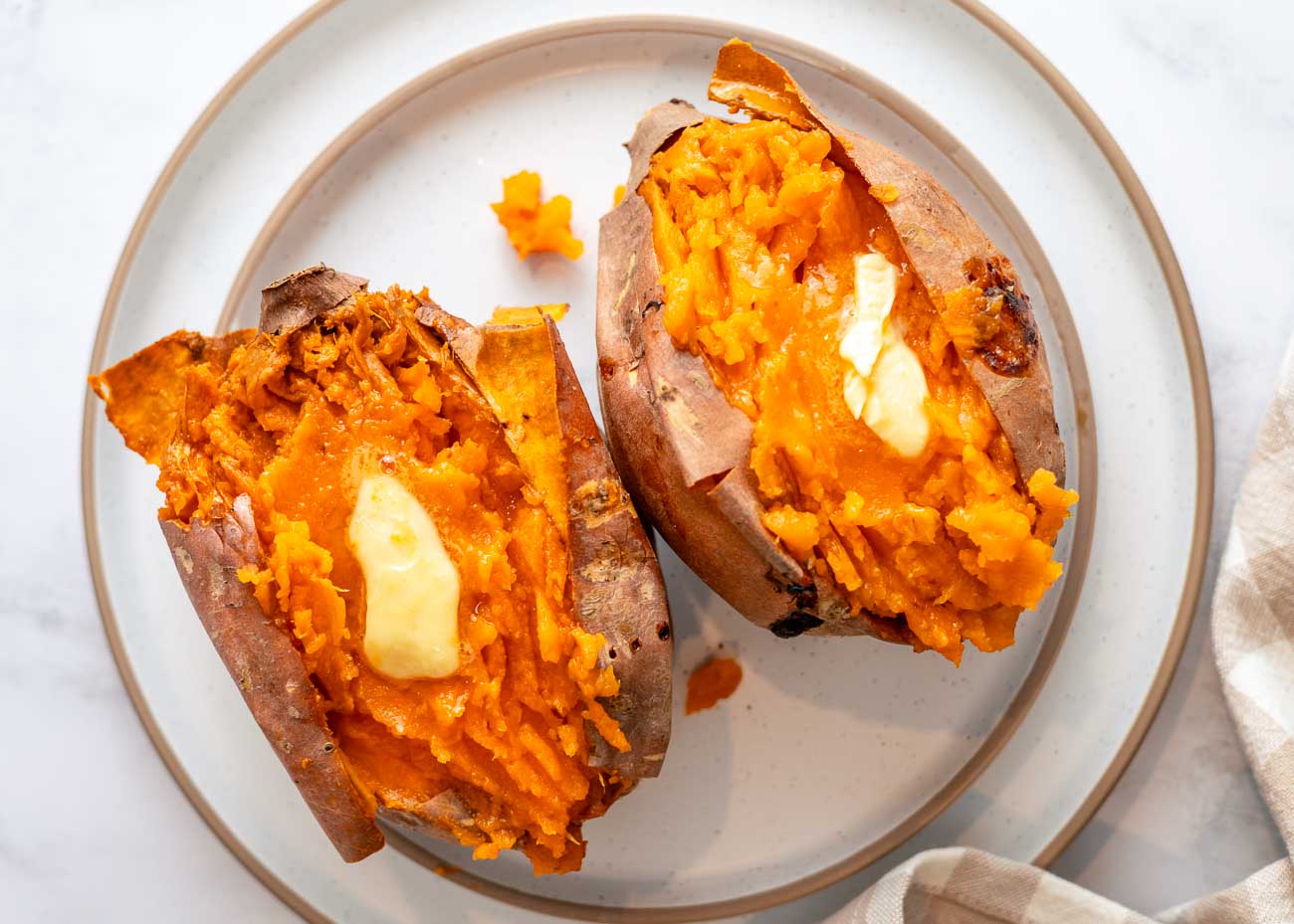 Fluffy inside of a baked sweet potato topped with butter melting.