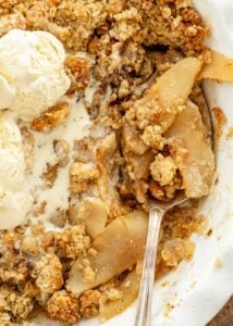 Close up of warm apple crisp served with vanilla ice cream.