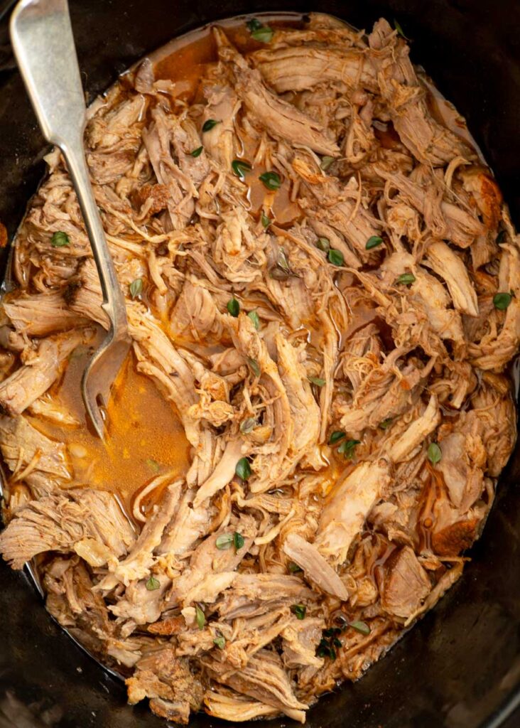 Juicy pulled pork soaking in crockpot juices.