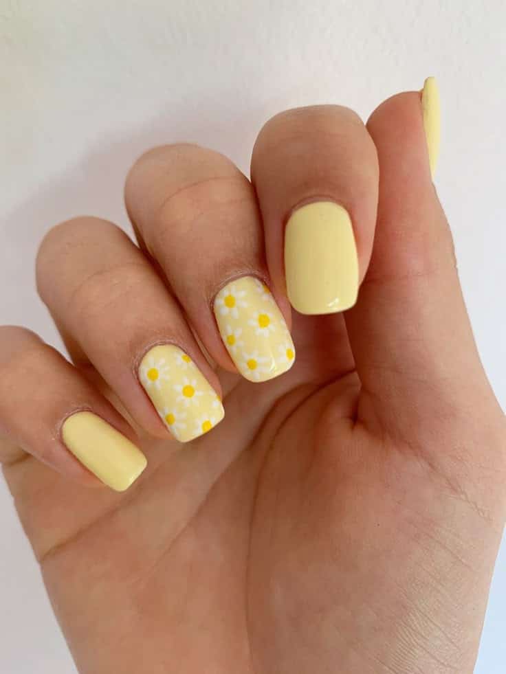 Butter yellow spring nails with daisy accent nail art