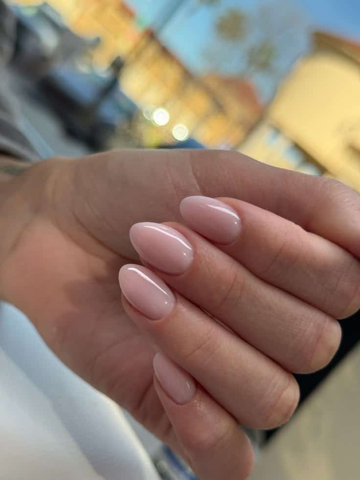 Almond-shaped nails in a sheer translucent baby pink gel polish