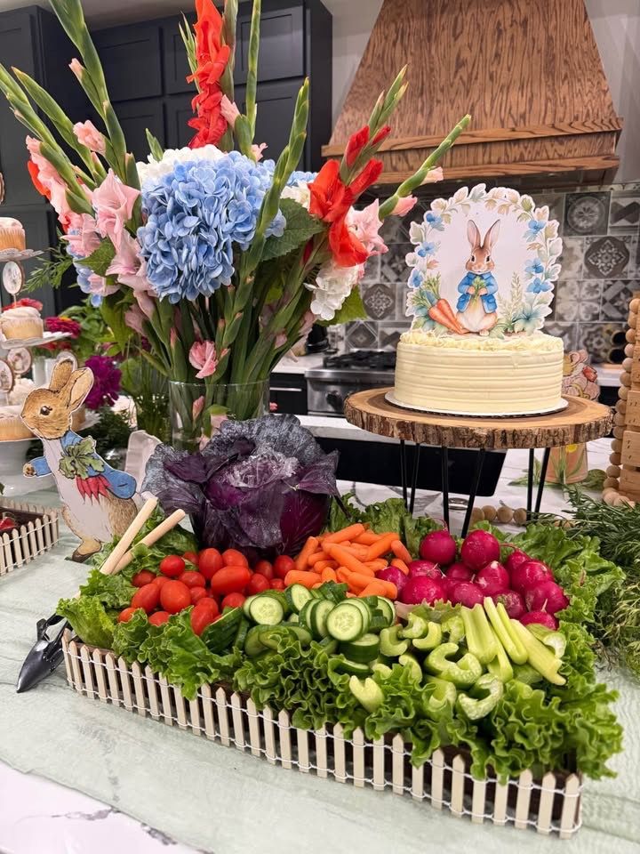 Peter Rabbit baby shower Mr McGregor's Garden crudite platter in a white picket fence tray with carrots tomatoes cucumber and celery and a purple cabbage dip bowl