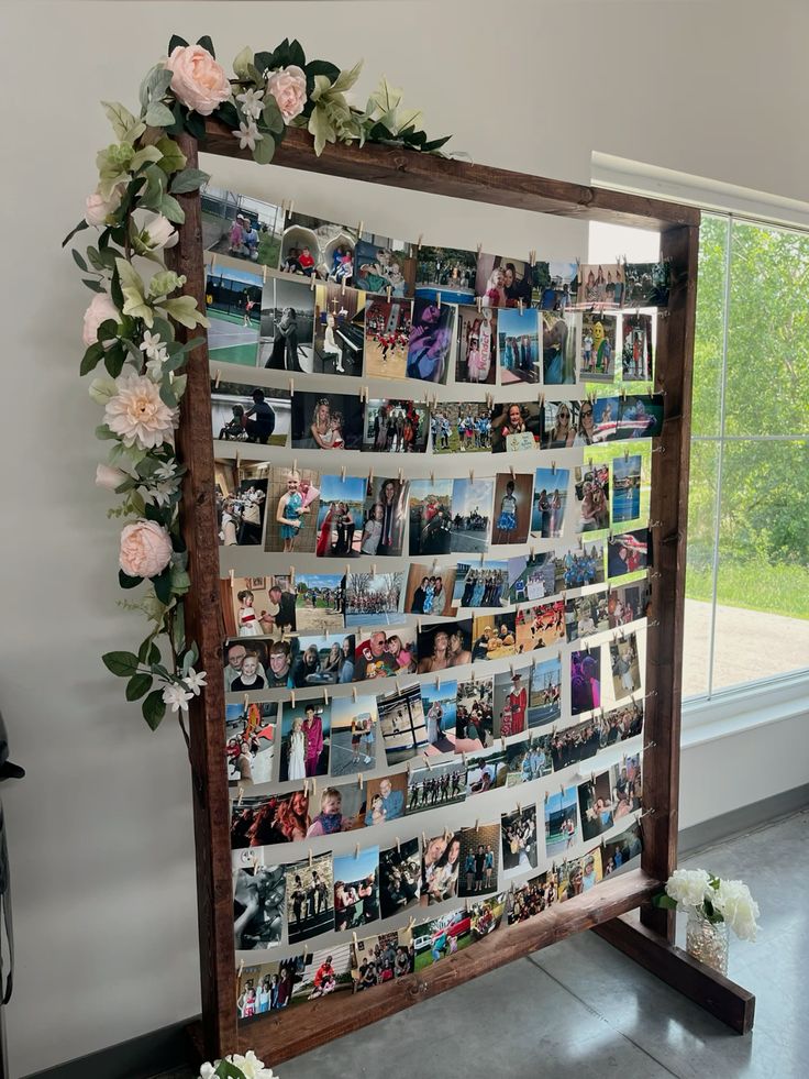 Wooden frame photo wall with rows of printed photos clipped with pegs showing memories from a graduate's life decorated with a pink floral garland