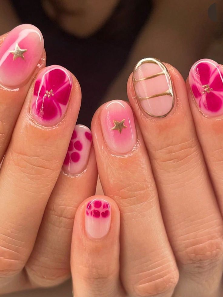 Short oval nails featuring a mix of hand-painted fuchsia flowers on a natural base, gold oval line art, pink ombre, and pink dot accents