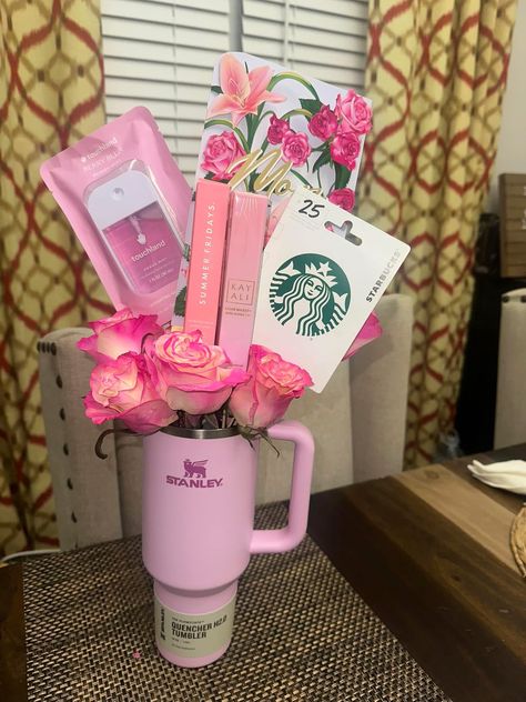 Pink Stanley Quencher H2.0 tumbler filled with bright pink roses, a Starbucks gift card, Summer Fridays lip gloss, and Touchland hand sanitizer