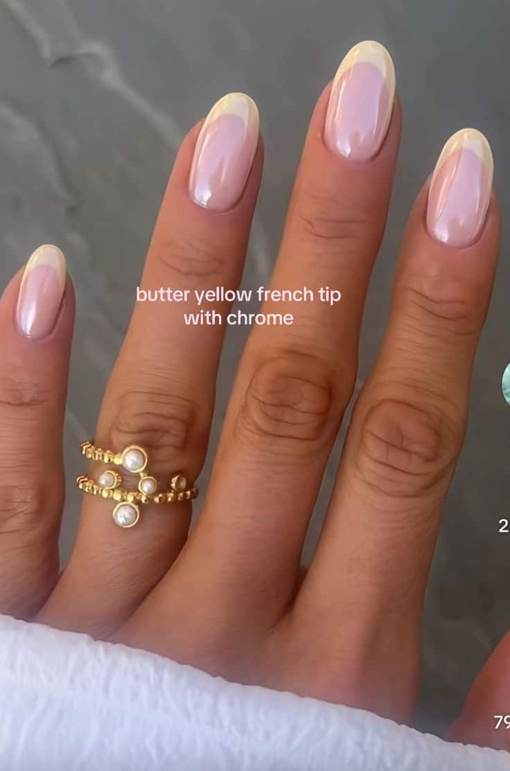 Almond nails with butter yellow French tips and a pearly chrome finish.