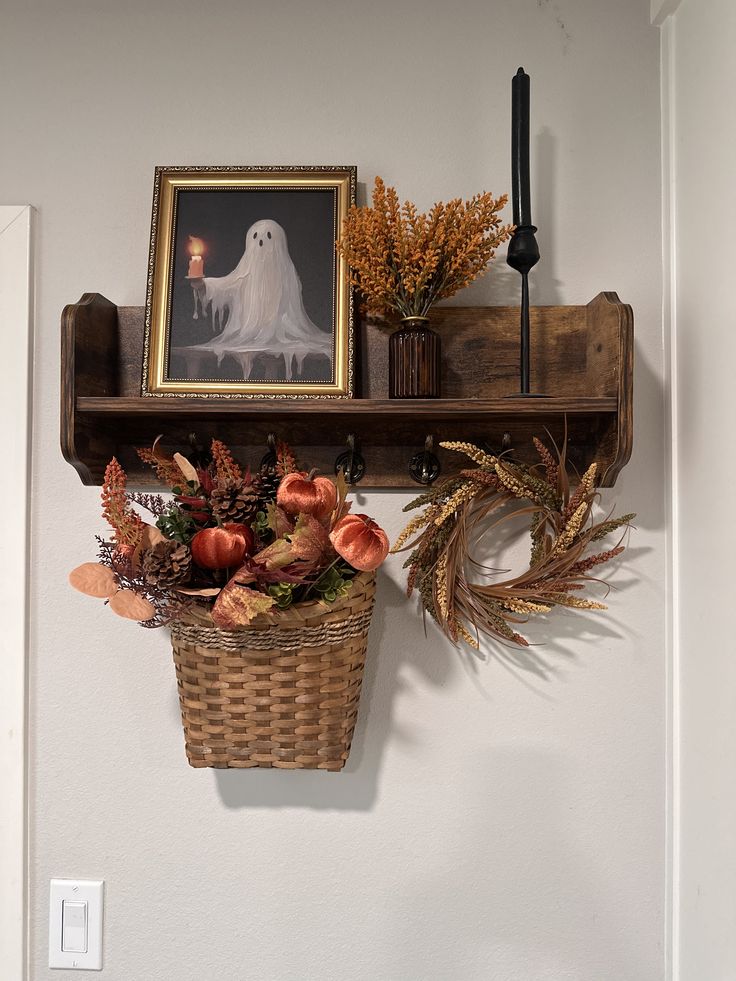 Cottage peg shelf styled with a spooky print and a hanging basket of fall florals