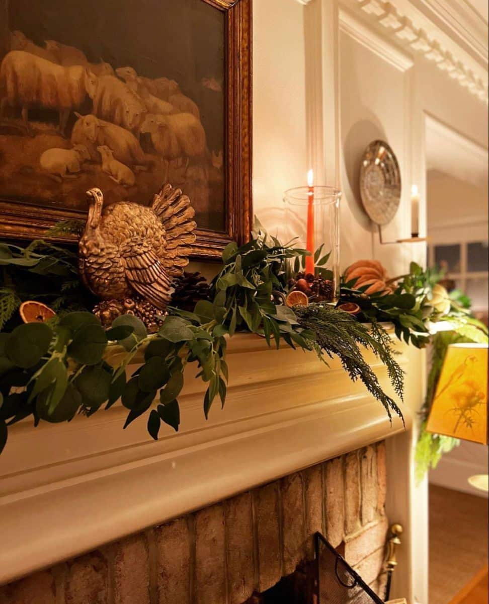 Fresh eucalyptus and cedar garland along a mantel with dried orange slices