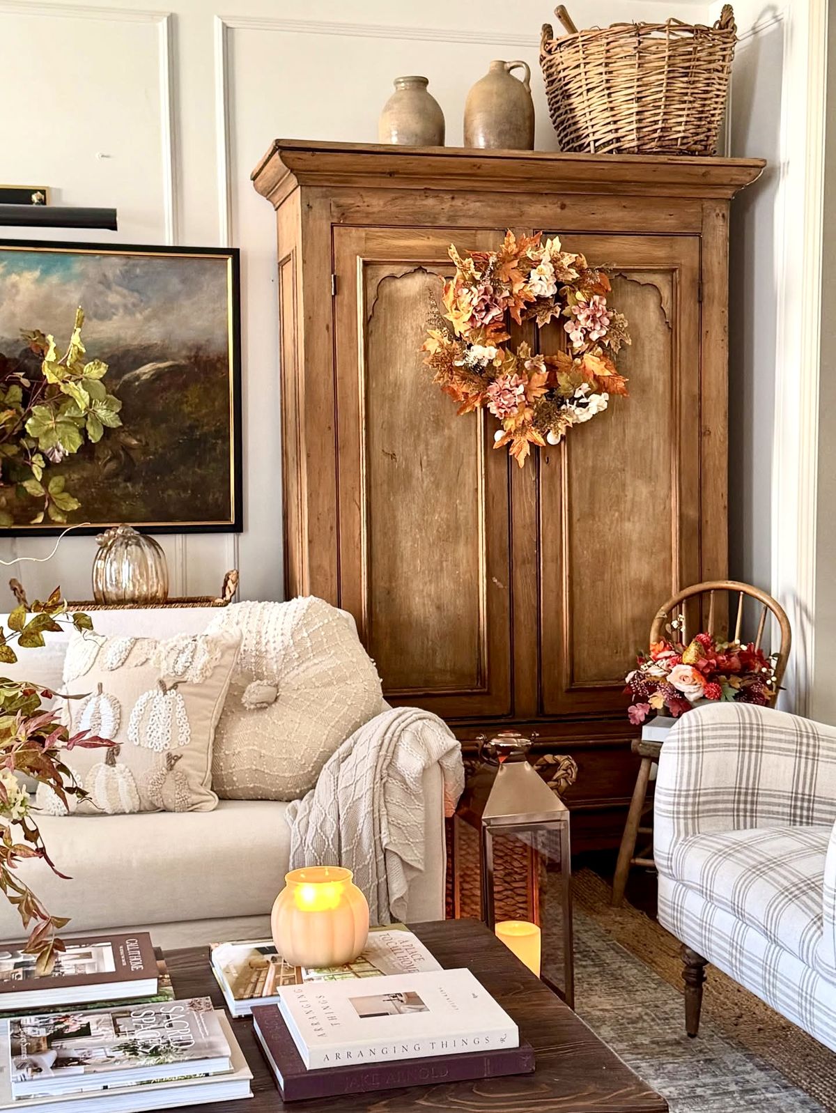 Autumn floral wreath hung on an antique pine armoire in a cosy living room