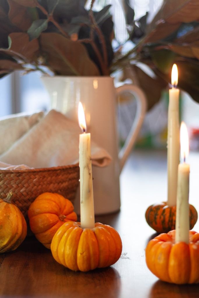 Mini pumpkins used as taper candle holders for a fall table