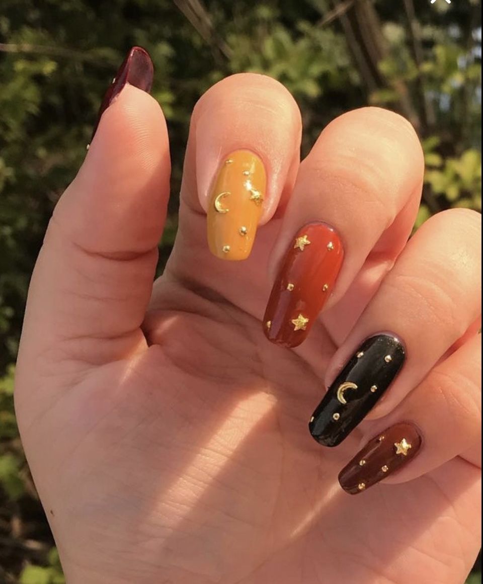 Long fall nails in mustard, rust and black with gold moon and star studs