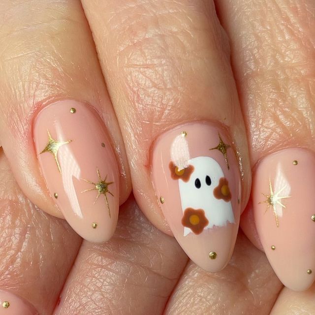Nude pink fall nails with gold stars and a flower ghost accent