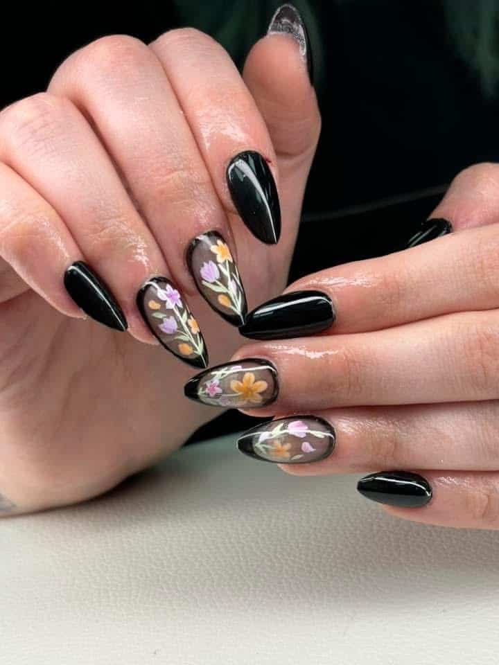 Glossy black almond nails with pressed wildflower art