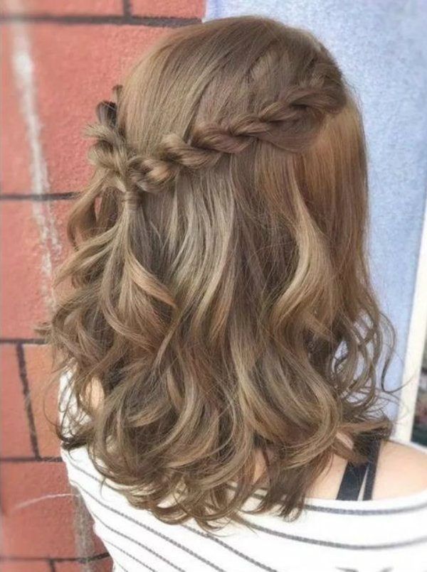 Wavy hair with rope twists from each side joined into a half up crown.