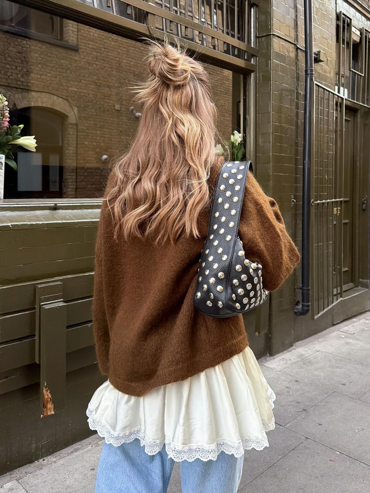Bronde wavy hair in a high messy half up top knot photographed from behind.