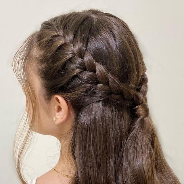Long brown hair with a side dutch braid feeding into a half up ponytail.
