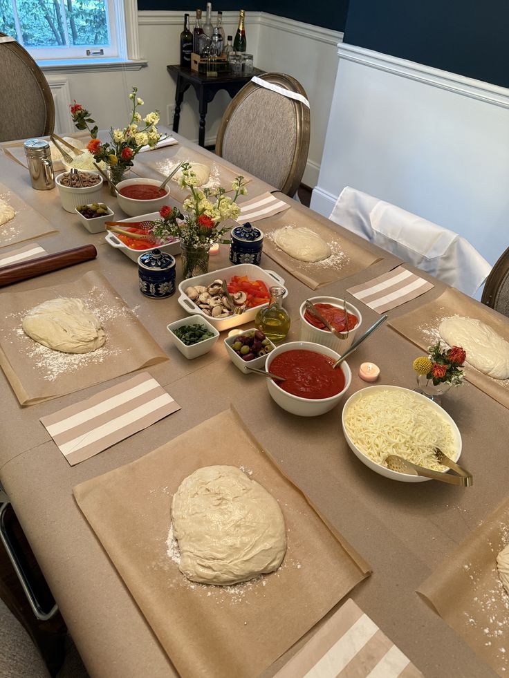 Dinner party table set up with individual pizza dough balls and shared topping bowls