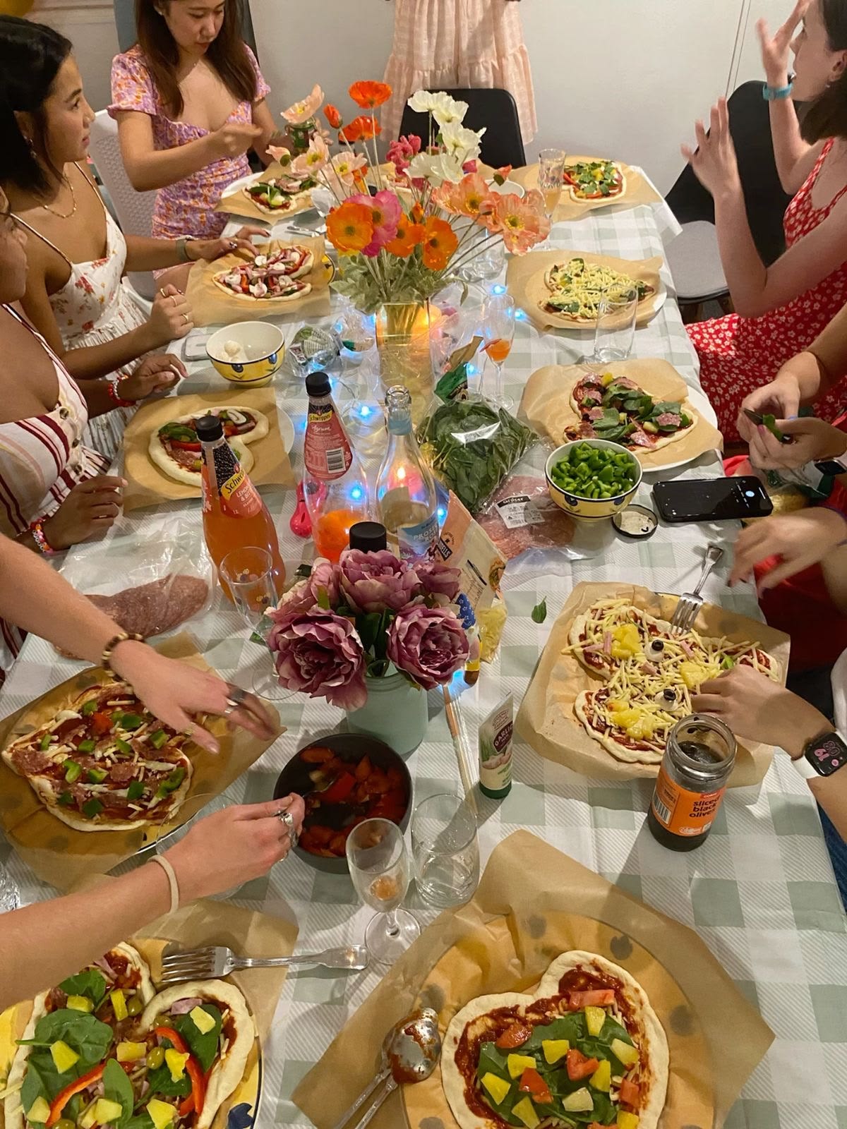 Girls night pizza party table with colourful flowers and heart shaped pizzas
