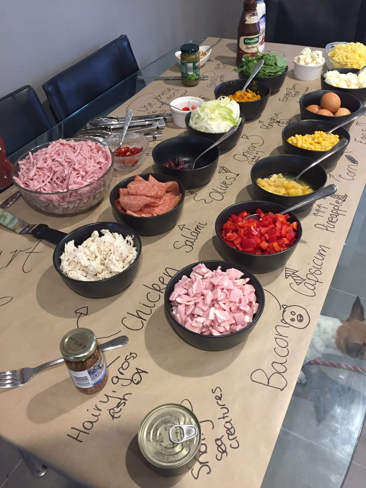 Build your own pizza topping bar with labelled bowls of ingredients