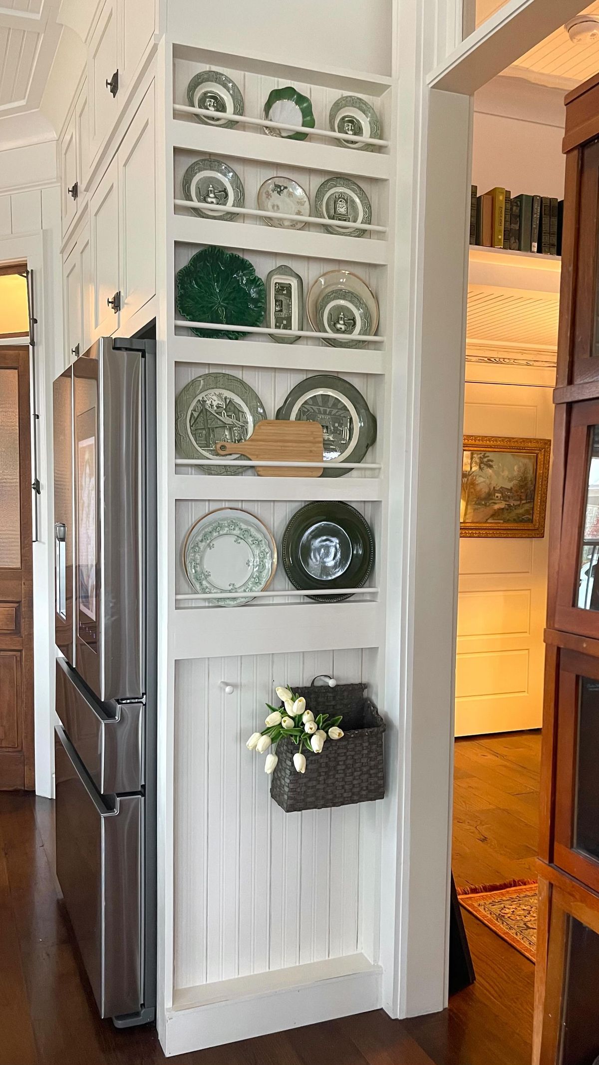 White plate rack on the end of kitchen cabinets styled with a green plate collection