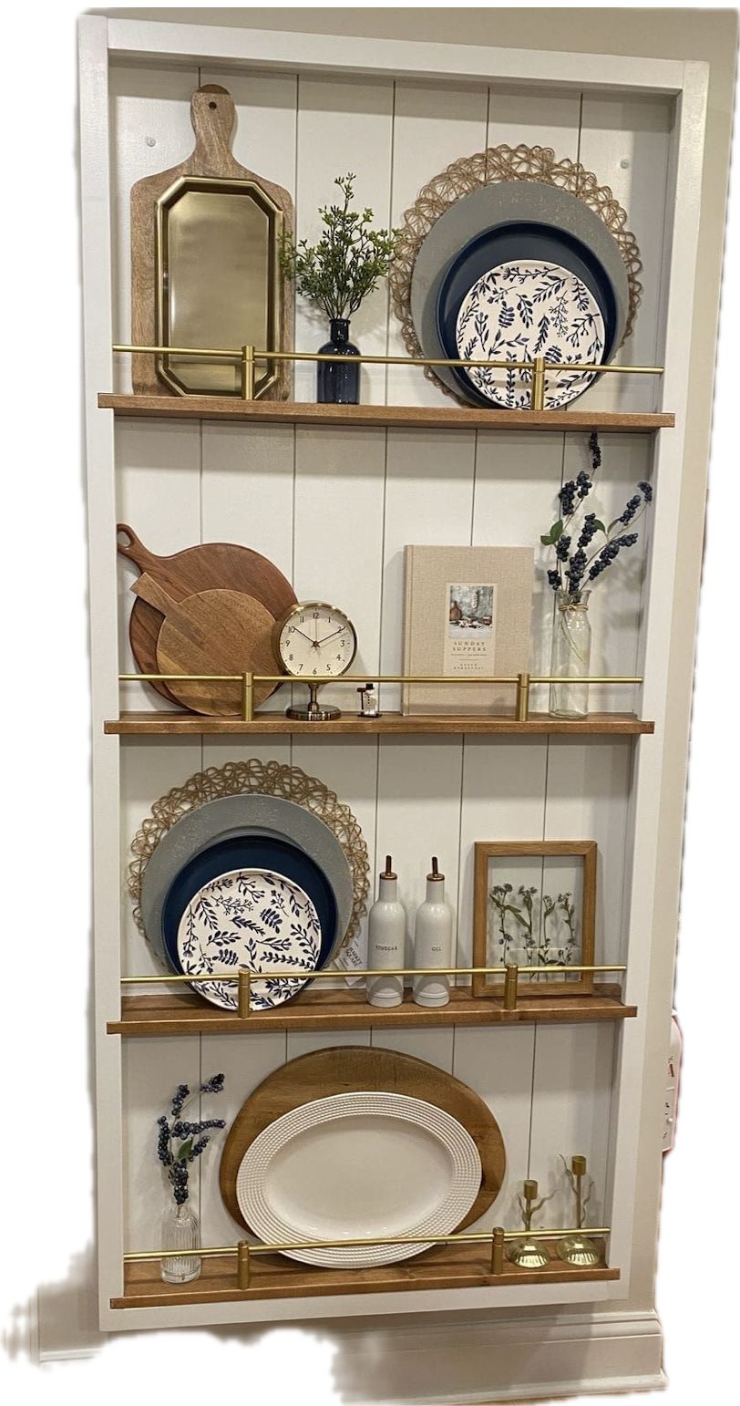White shiplap plate rack with brass rails layering woven chargers behind patterned plates