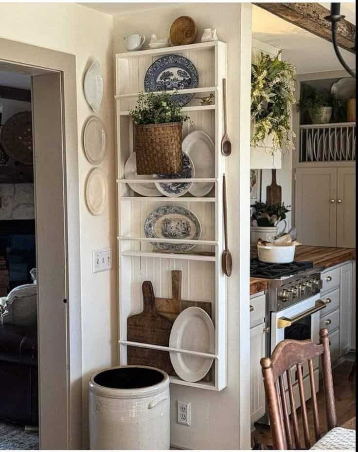 Slim white plate rack tucked into a cottage kitchen corner with blue transferware and a basket