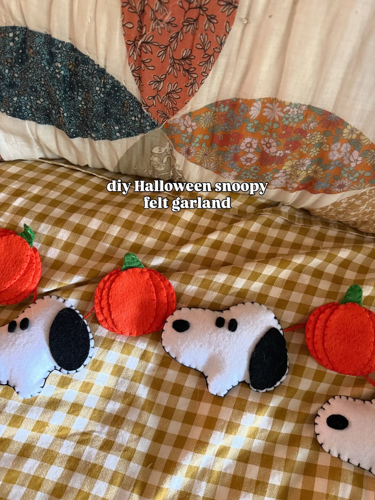 Felt garland of blanket-stitched pumpkins and a cartoon dog on gingham fabric