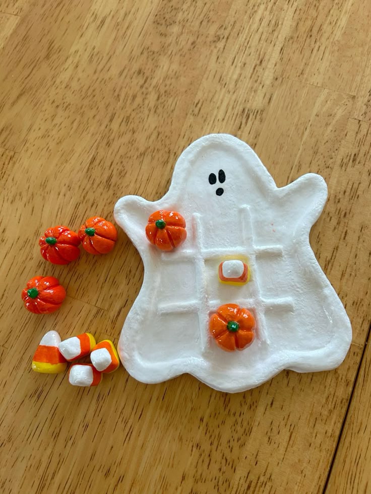 Air-dry clay ghost dish set up as a tic-tac-toe board with clay pumpkins