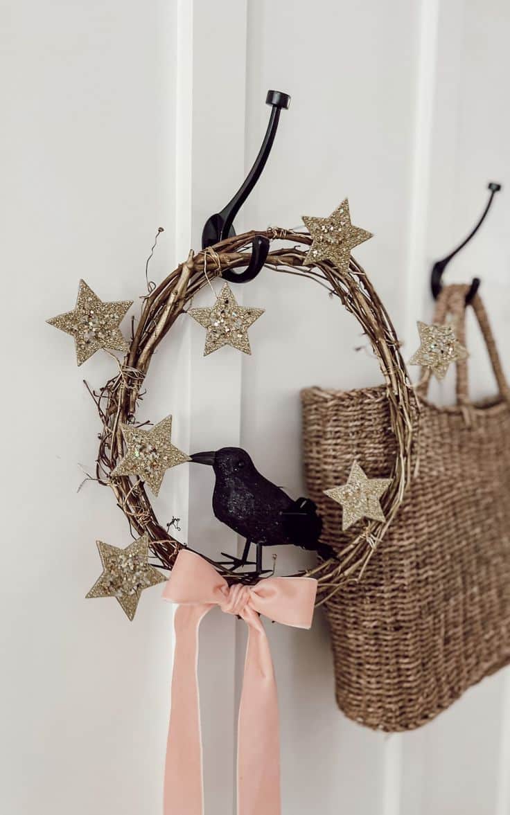 Grapevine wreath with glittered gold stars, a black crow and a trailing ribbon