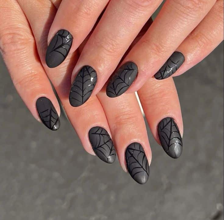 Matte black almond nails with glossy black spiderweb detailing